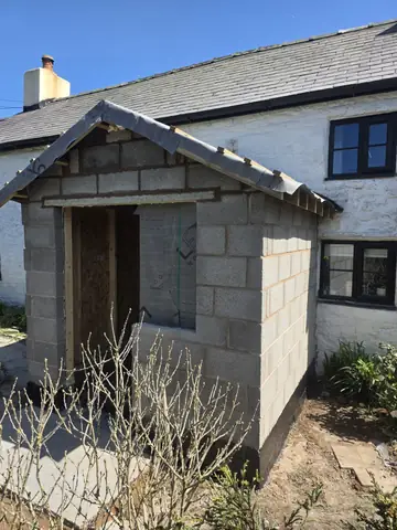 Blockwork porch walls with roof battens and an open doorway